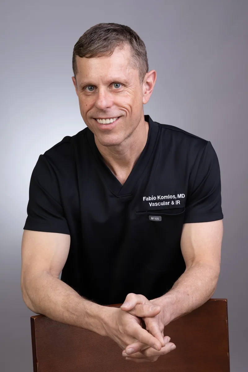 Dr. Fabio Komlos in black scrubs, smiling