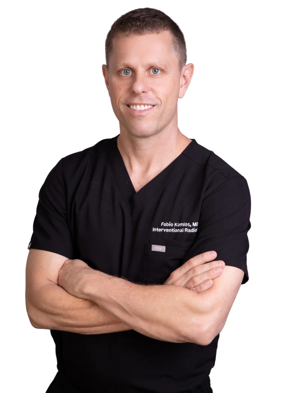 Dr. Fabio Komlos in black scrubs, arms crossed